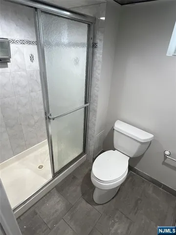 a bathroom with a granite countertop toilet sink and mirror
