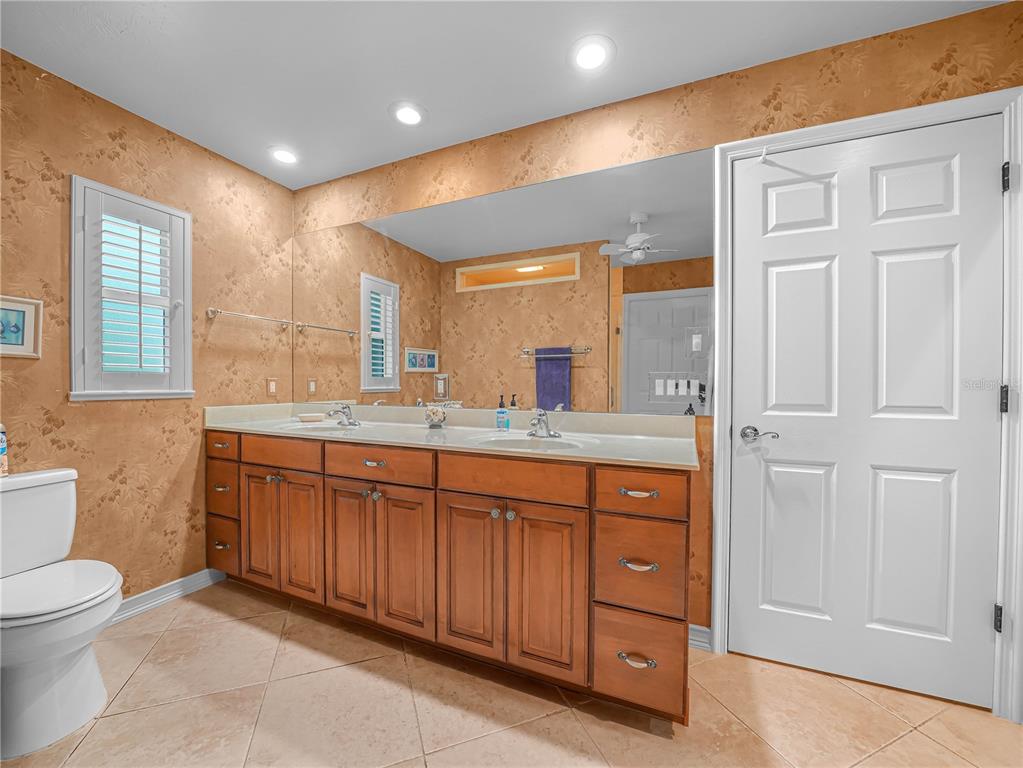 5001 Lakewood Road Sebring, FL 33875 - Photo 13 of 28 a bathroom with a granite countertop double vanity sink a mirror and a toilet