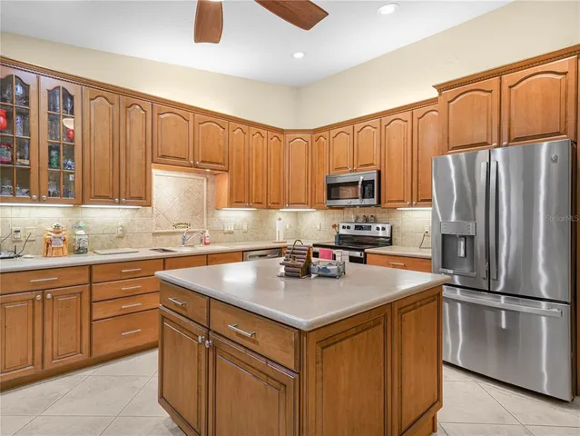 a kitchen with a sink a microwave a refrigerator and cabinets