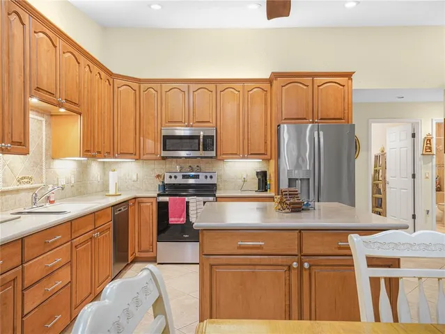 a kitchen with kitchen island granite countertop a sink stove and refrigerator