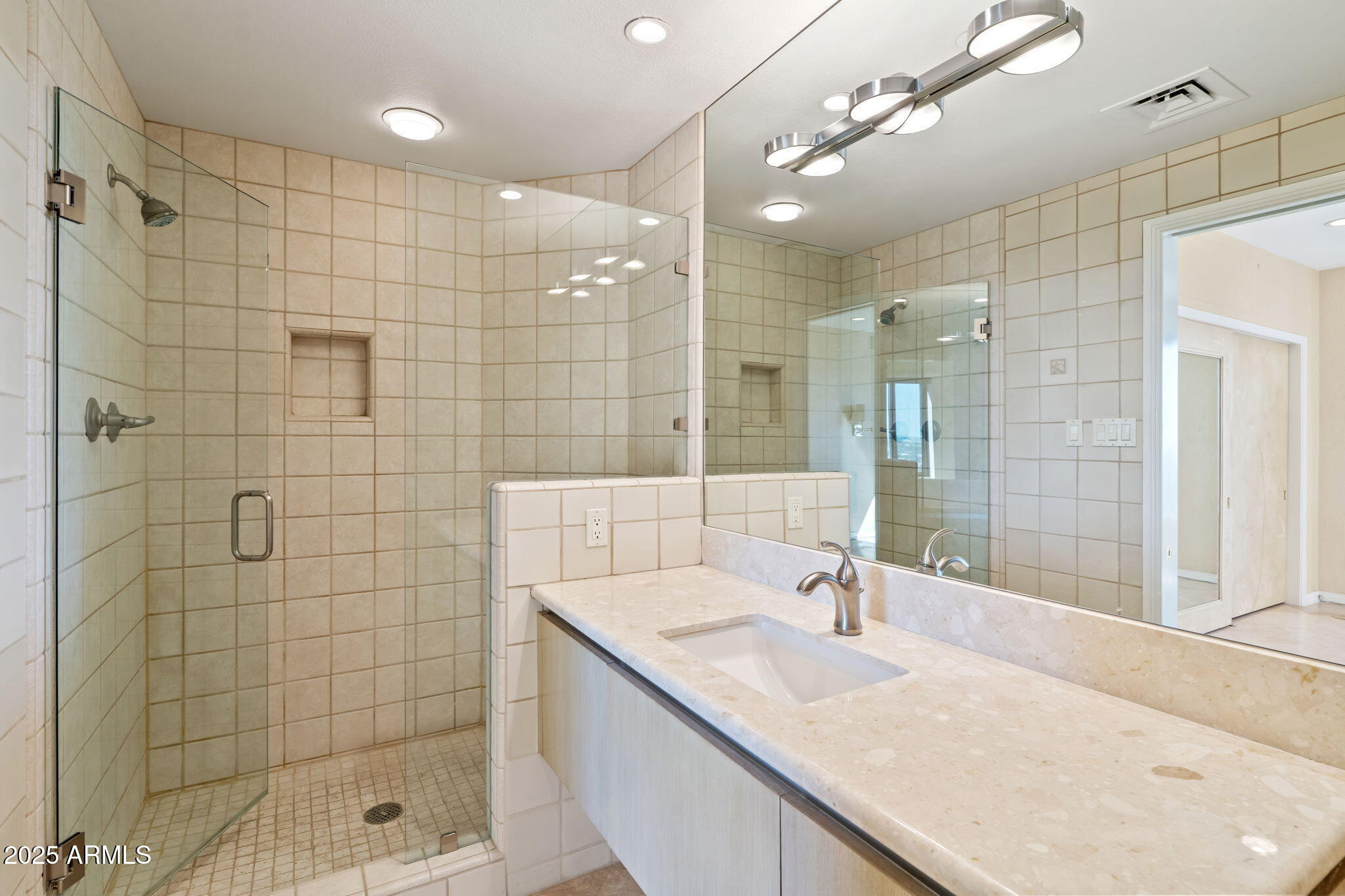 1040 East Osborn Road, Unit 1602 Phoenix, AZ 85014 - Photo 54 of 66 a bathroom with a granite countertop sink a mirror and shower