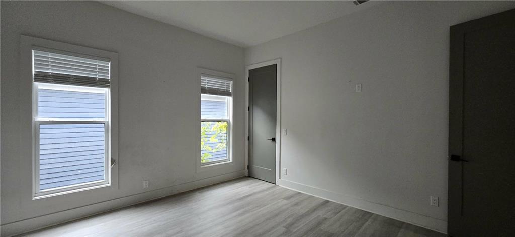 762 Cooper Street Southwest Atlanta, GA 30315 - Photo 33 of 43 an empty room with wooden floor and windows