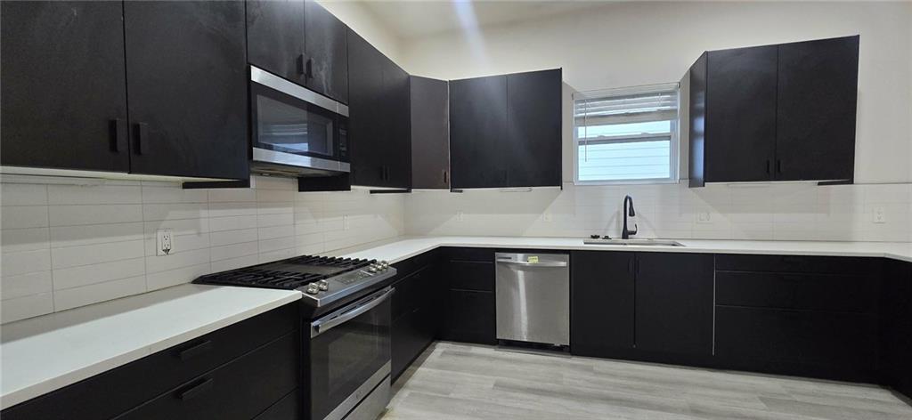 762 Cooper Street Southwest Atlanta, GA 30315 - Photo 10 of 43 a kitchen with a sink dishwasher a stove and a microwave oven