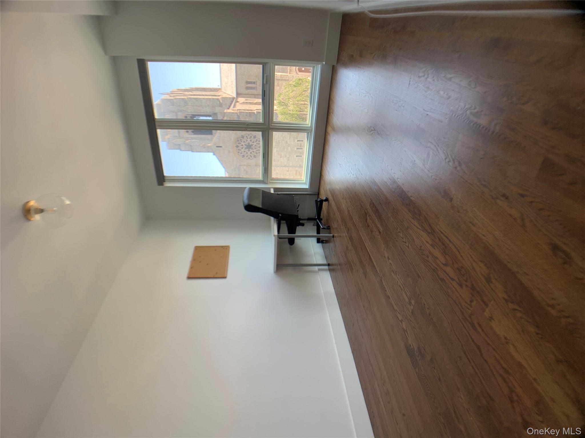 109-19 72nd Road, Unit 4C Queens, NY 11375 - Photo 13 of 16 a view of an empty room with wooden floor and a window