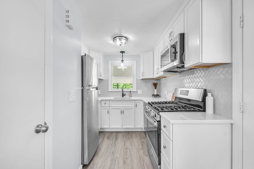 13 Lorimer Street Chicopee, MA 01013 - Photo 15 of 42 a kitchen with stainless steel appliances granite countertop a stove a sink and a refrigerator