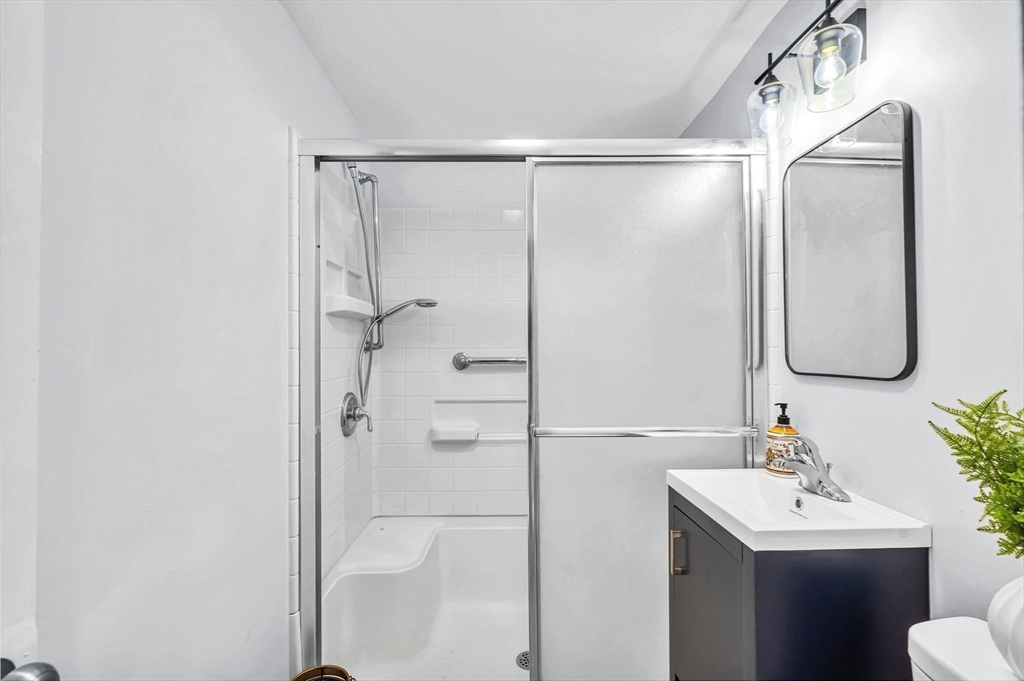 13 Lorimer Street Chicopee, MA 01013 - Photo 23 of 42 a bathroom with a shower sink vanity and mirror