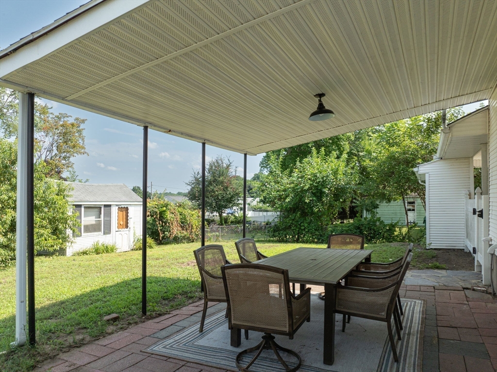 13 Lorimer Street Chicopee, MA 01013 - Photo 6 of 42 a view of a patio with table and chairs and floor to ceiling window with garden