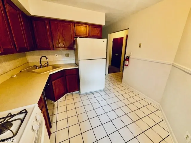 a kitchen with a refrigerator a stove a sink and cabinets
