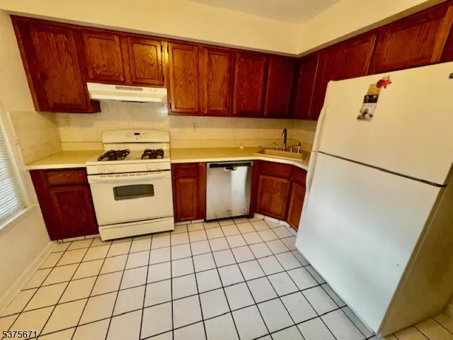 a kitchen with a stove a refrigerator and a sink