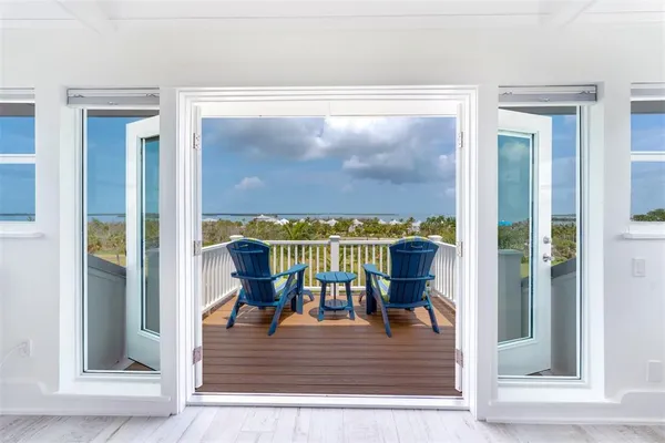 a view of swimming pool from balcony with furniture