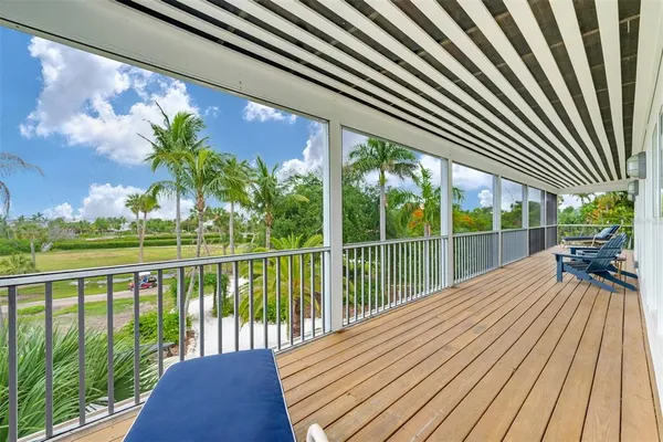 a view of balcony with wooden floor & fence