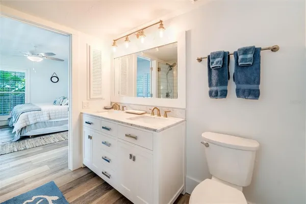 a bathroom with a granite countertop sink mirror and toilet