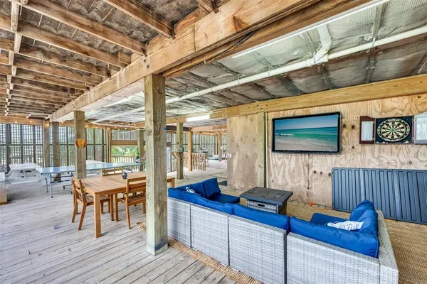 a living room with patio furniture and a flat screen tv