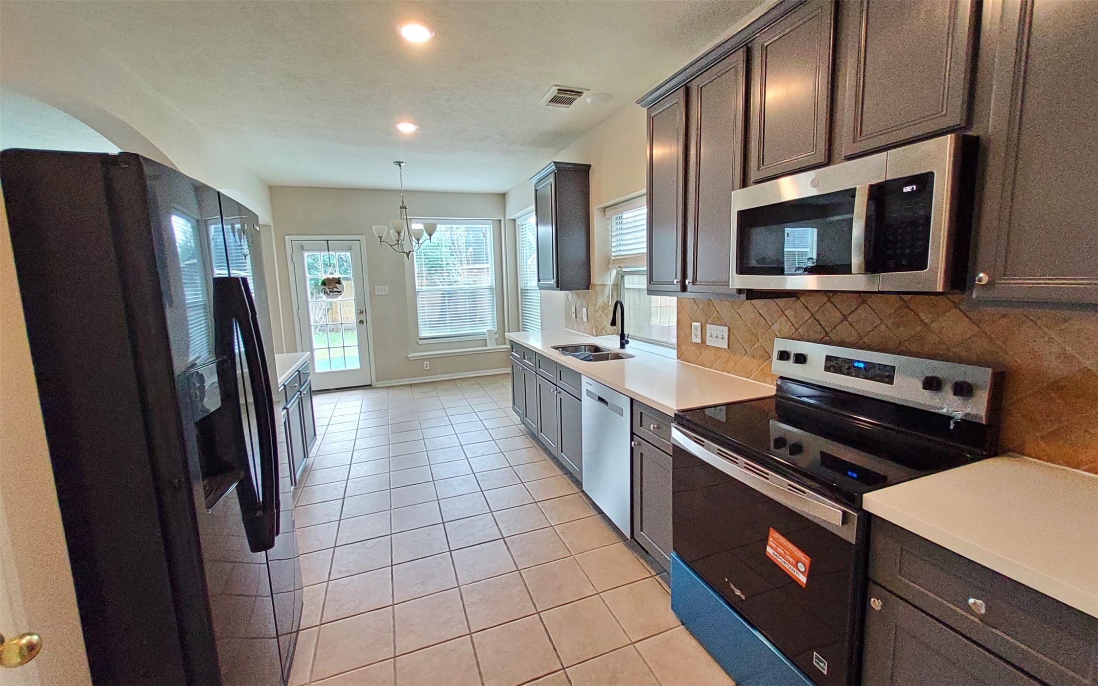 2906 Humble Drive Manvel, TX 77578 - Photo 7 of 34 a kitchen with stainless steel appliances a refrigerator and a stove top oven