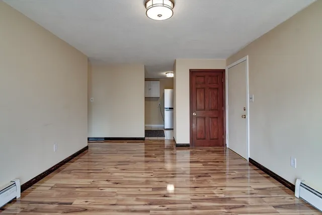 a view of empty room with wooden floor