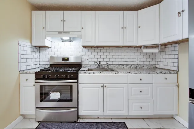 a kitchen with white cabinets and appliances