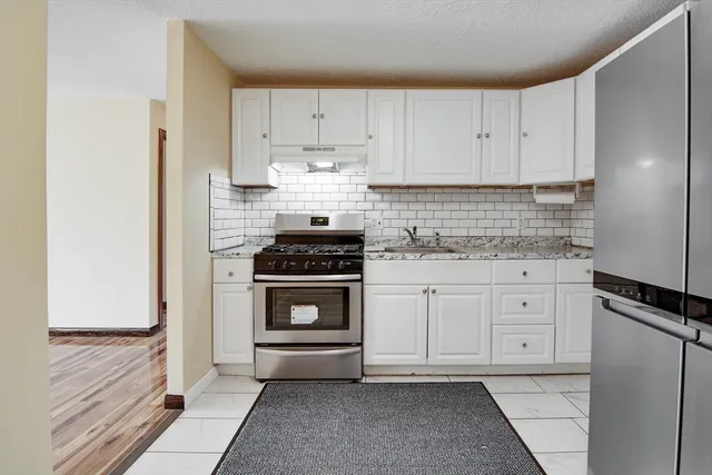 a kitchen with white cabinets and white appliances