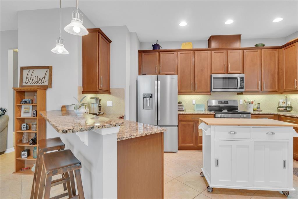 306 Reed Grass Drive Oviedo, FL 32765 - Photo 5 of 33 a kitchen with stainless steel appliances granite countertop a refrigerator stove microwave and sink