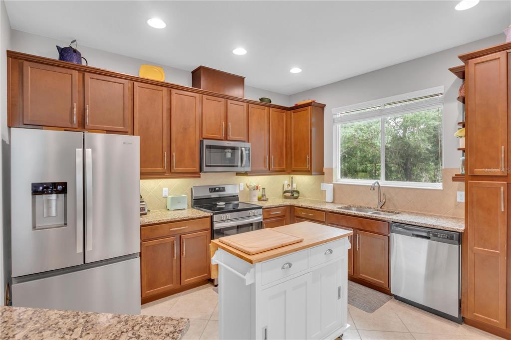 306 Reed Grass Drive Oviedo, FL 32765 - Photo 6 of 33 a kitchen with a sink a refrigerator a stove and cabinets