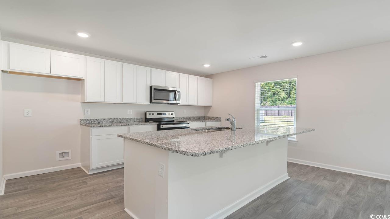 322 Acosta Circle Conway, SC 29527 - Photo 6 of 27 Kitchen with a kitchen island with sink, white cab