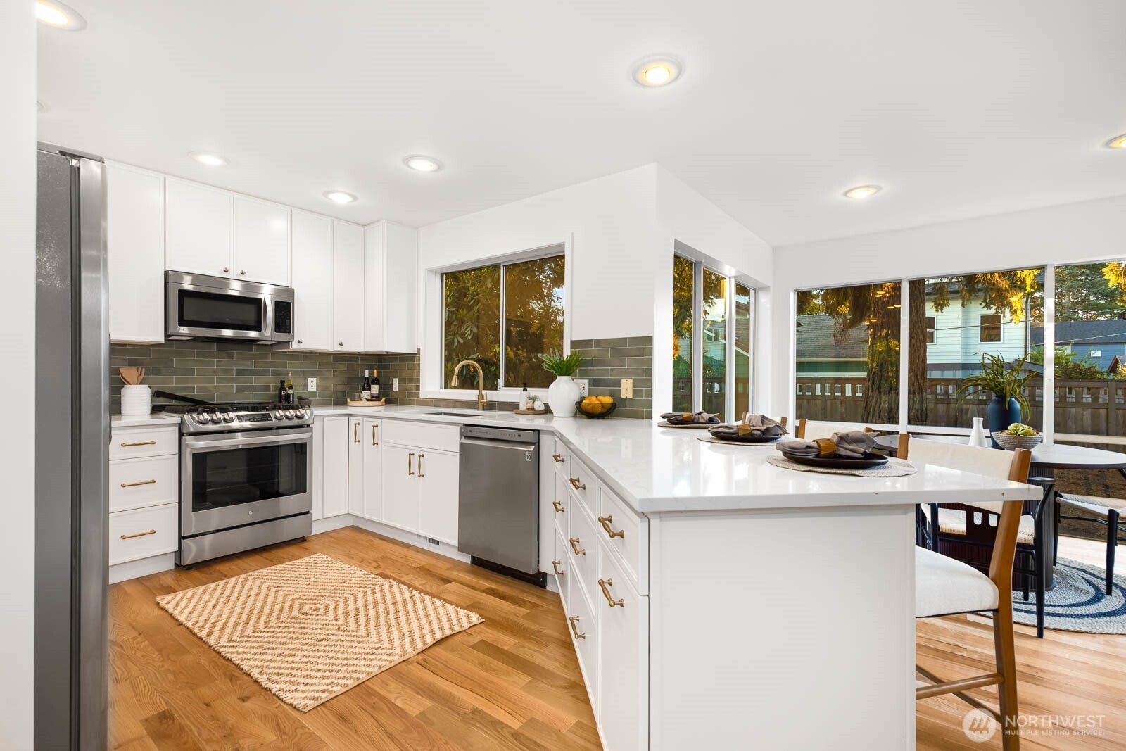 4922 Southwest Hudson Street Seattle, WA 98116 - Photo 10 of 37 a kitchen with stainless steel appliances kitchen island granite countertop a stove a sink and a microwave