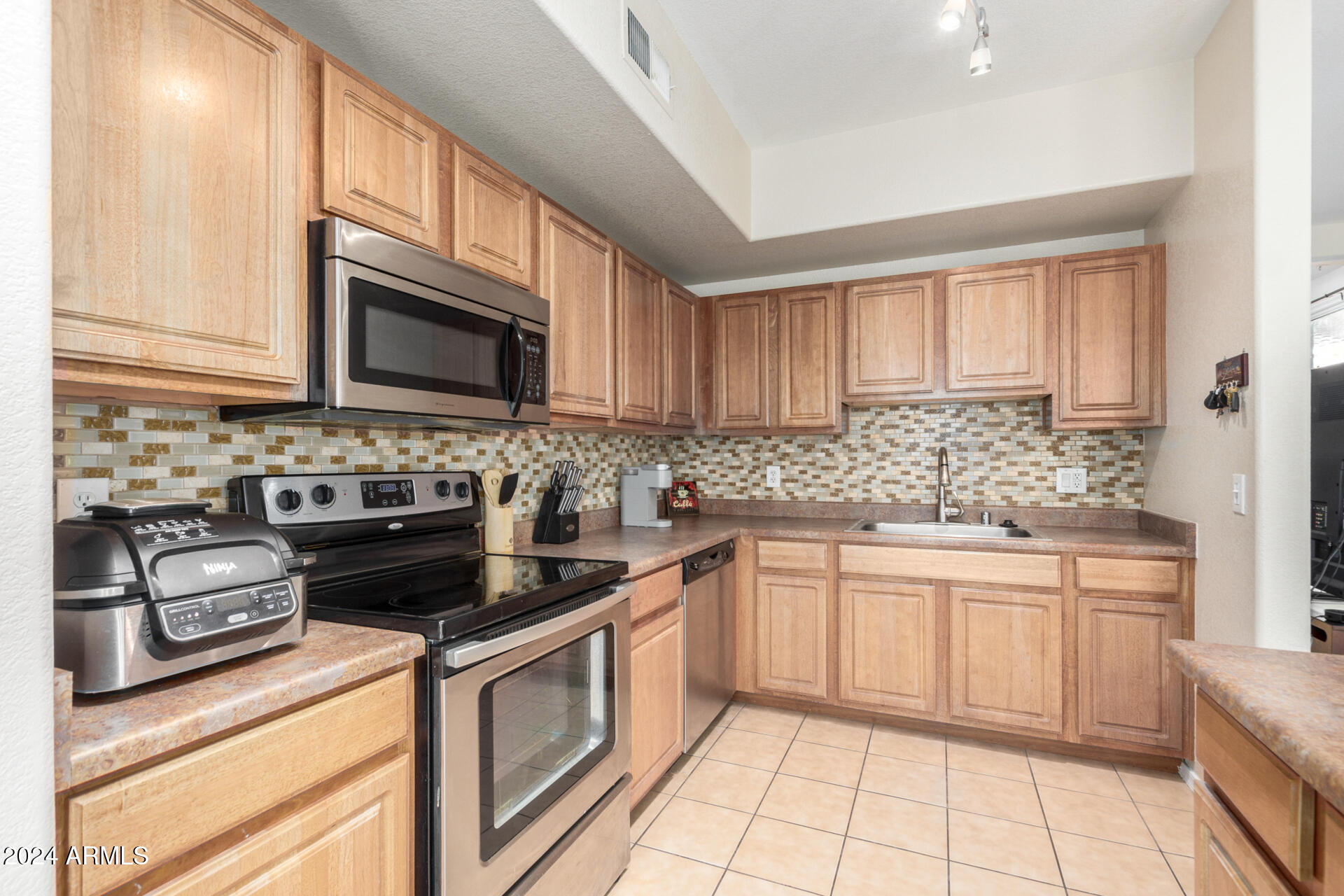 18250 North Cave Creek Road, Unit 163 Phoenix, AZ 85032 - Photo 11 of 32 a kitchen with cabinets appliances a sink and a counter top space