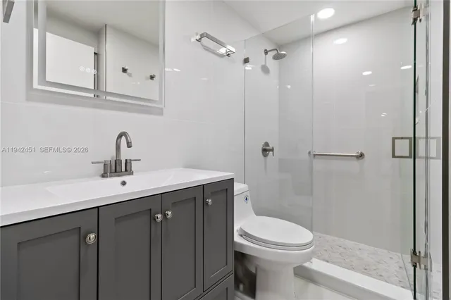 a bathroom with a sink a toilet and shower