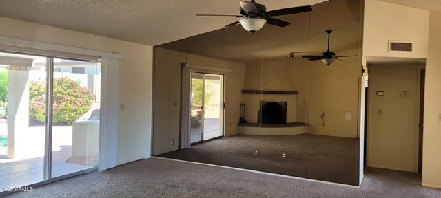a view of a livingroom with a fireplace and windows
