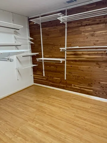a view of an empty room with wooden floor and cabinet