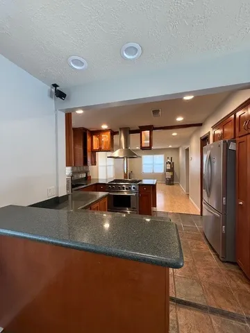 a kitchen with stainless steel appliances granite countertop a sink refrigerator and a stove