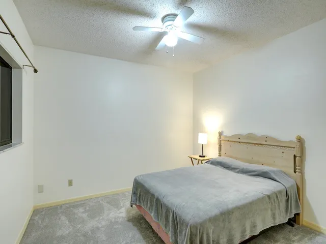 a bedroom with a bed and a ceiling fan