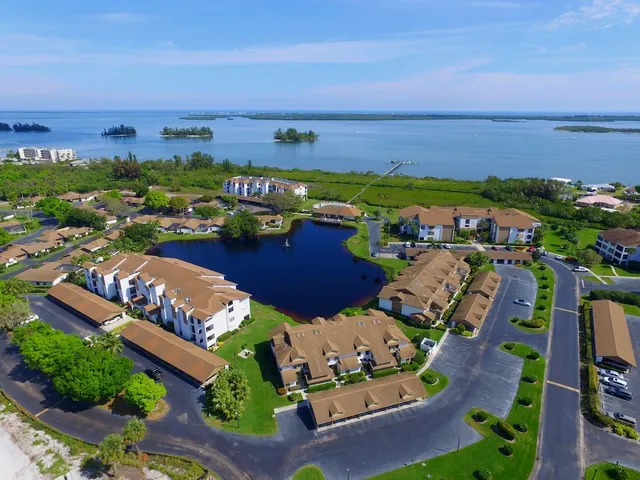an aerial view of a city with lots of residential buildings ocean and mountain view in back