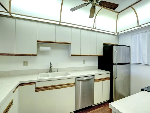 a kitchen with a sink a refrigerator and cabinets