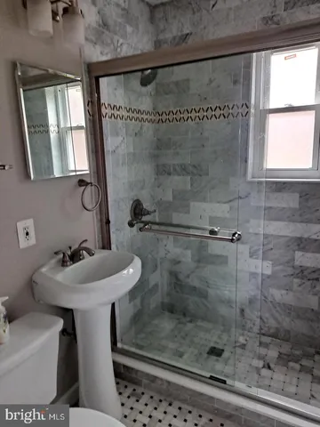 a bathroom with a sink mirror toilet and shower