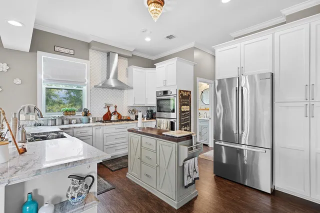 a kitchen with a refrigerator a sink dishwasher a stove and white cabinets with wooden floor