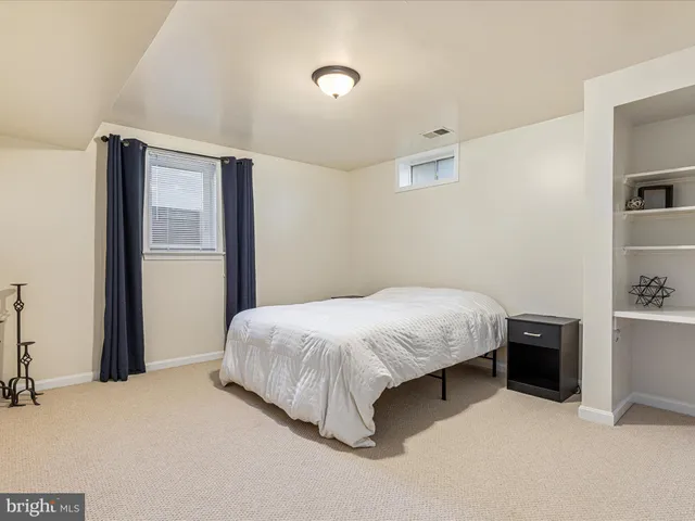 a spacious bedroom with a bed and a cabinets