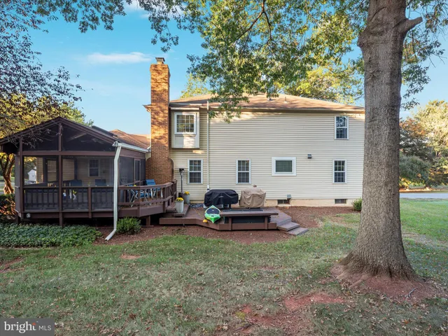 a view of a house with backyard and a tree