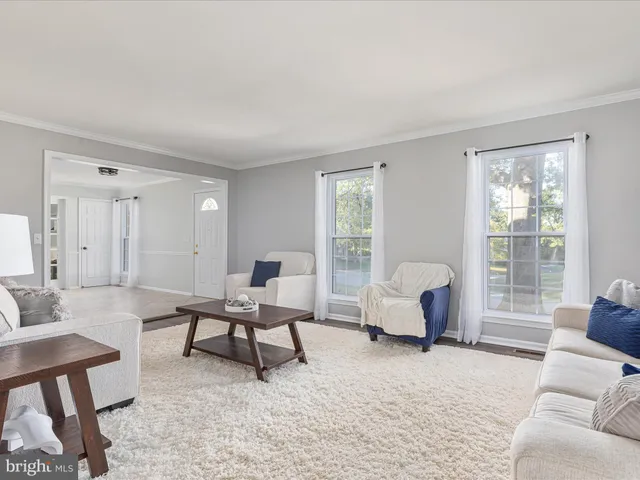 a living room with furniture and floor to ceiling window