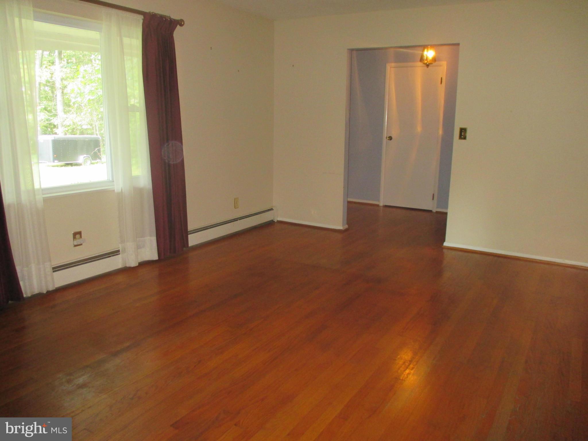 1601 Exeter Road Westminster, MD 21157 - Photo 4 of 19 a view of an empty room with wooden floor and a window