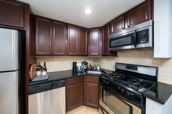 a kitchen with stainless steel appliances granite countertop a stove and a refrigerator