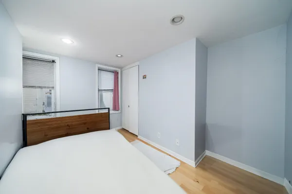 a room with a bed and wooden floor