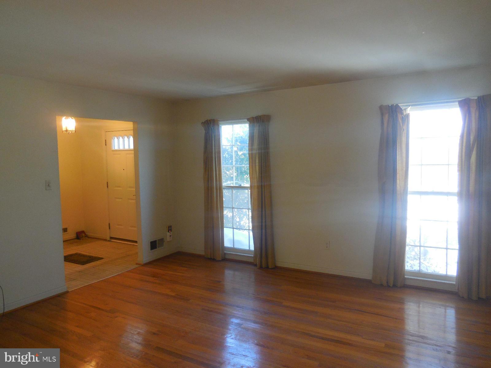 14221 Cantrell Road Silver Spring, MD 20905 - Photo 3 of 16 an empty room with wooden floor and windows