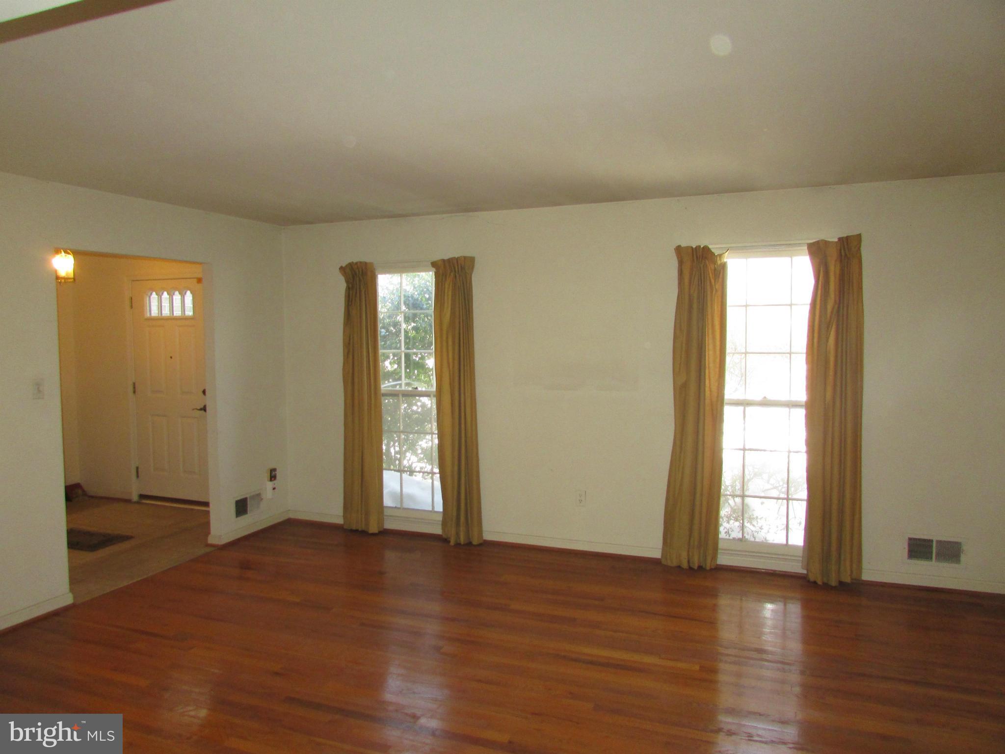 14221 Cantrell Road Silver Spring, MD 20905 - Photo 4 of 16 an empty room with wooden floor and windows