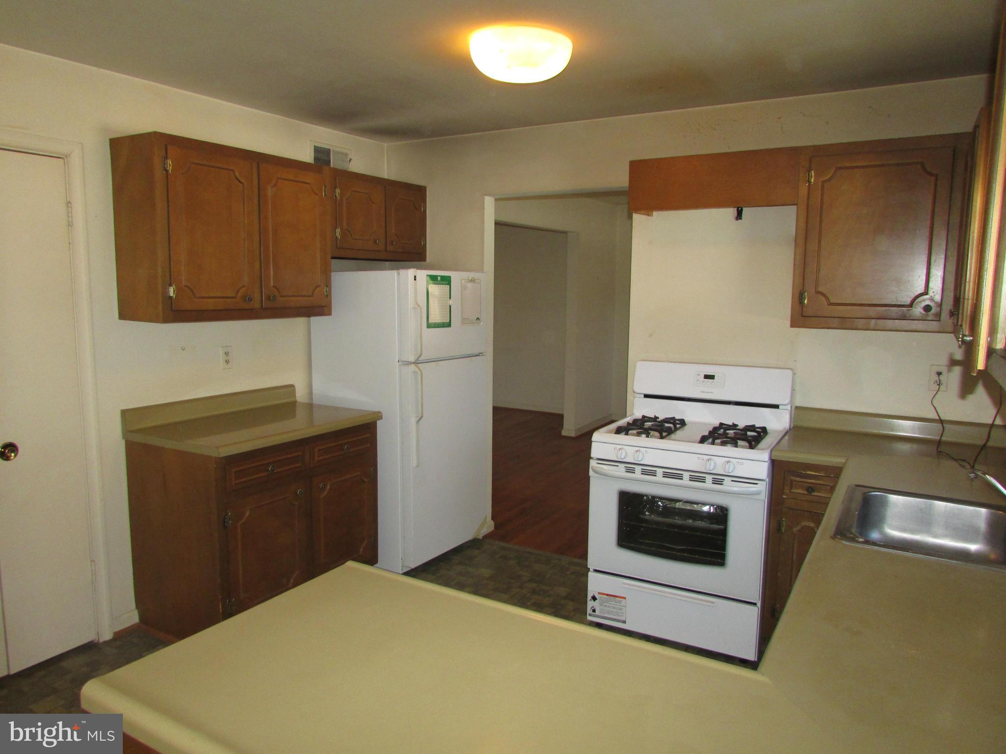 14221 Cantrell Road Silver Spring, MD 20905 - Photo 7 of 16 a kitchen with a stove refrigerator and microwave