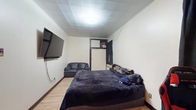 a bedroom with a bed and a flat screen tv
