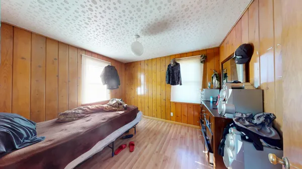 a bedroom with bed and wooden floor