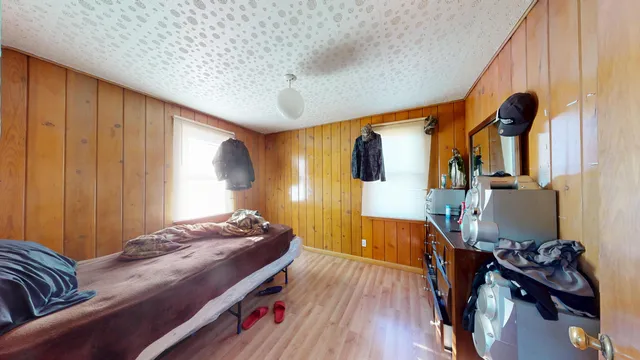 a bedroom with bed and wooden floor