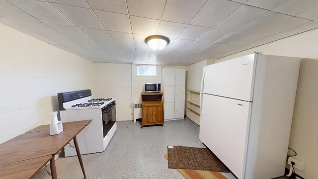 a view of kitchen with furniture and refrigerator