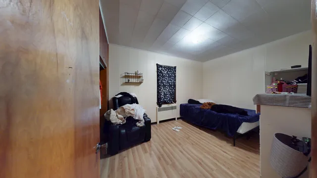 a living room with furniture and a dresser with wooden floor