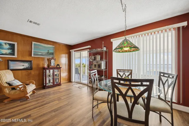 a living room with furniture a wooden floor and next to a window